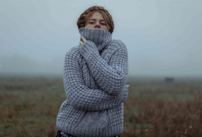 Femme qui porte un pull en cachemire bleu