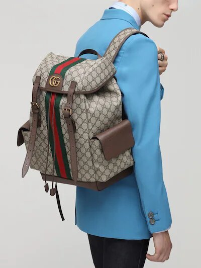 Ophidia backpack from Gucci carried by a man wearing a blue jacket