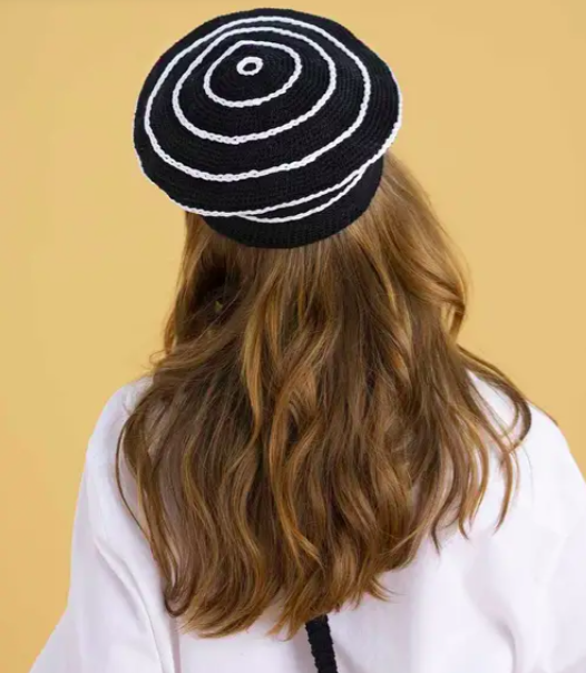 Woman with brown hair wearing a beret from the brand Phildar 