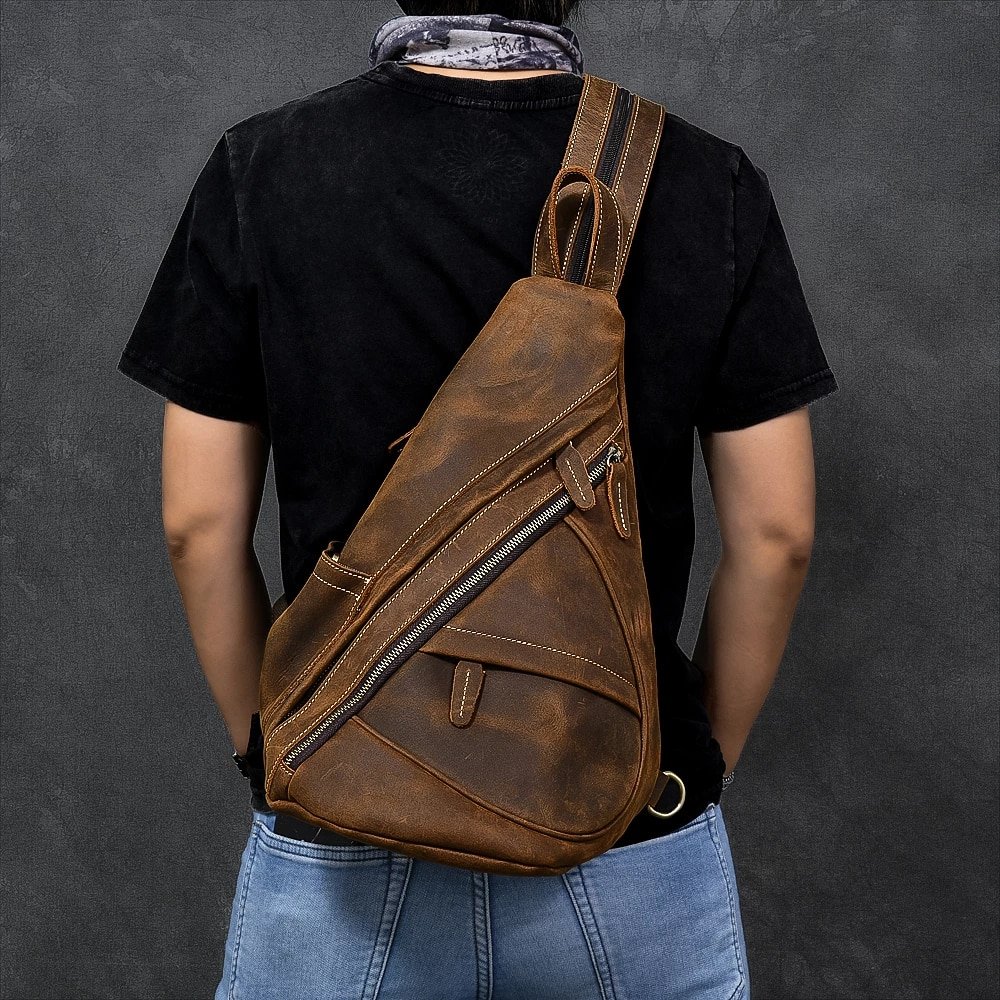 Man wearing a brown leather sling backpack