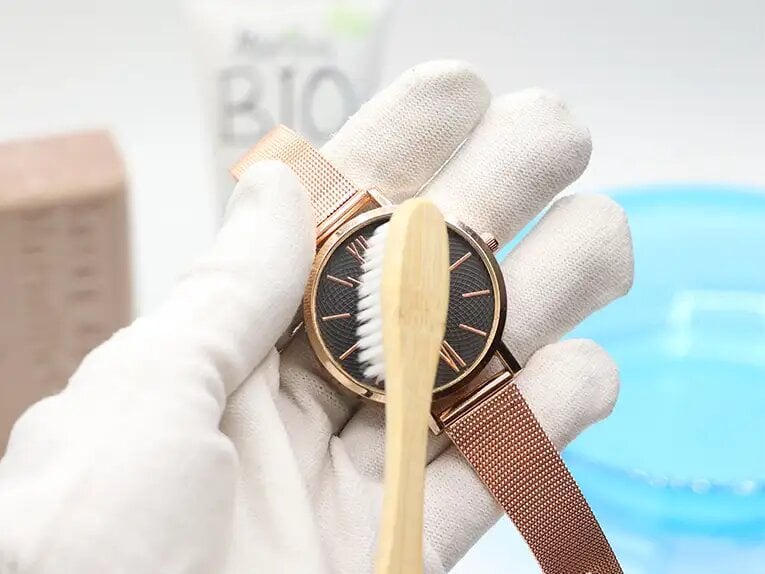 Cleaning a women's watch with a toothbrush