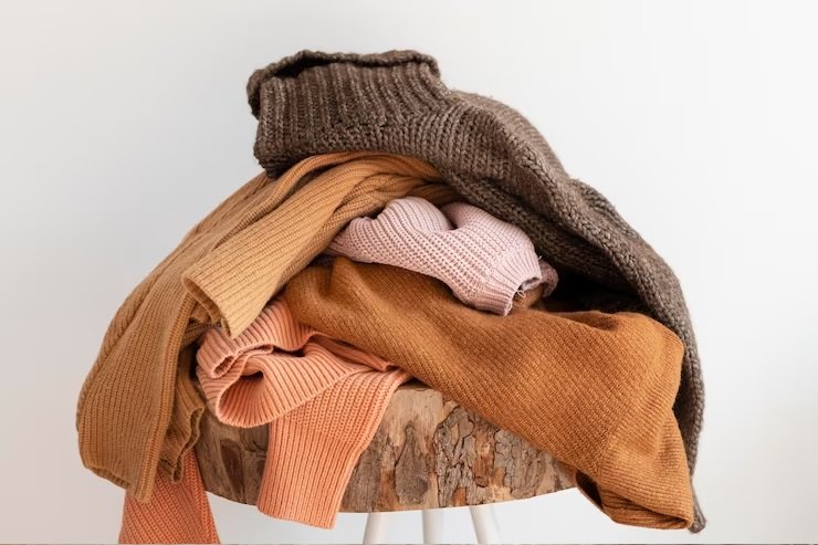 A pile of cardigans on a chair