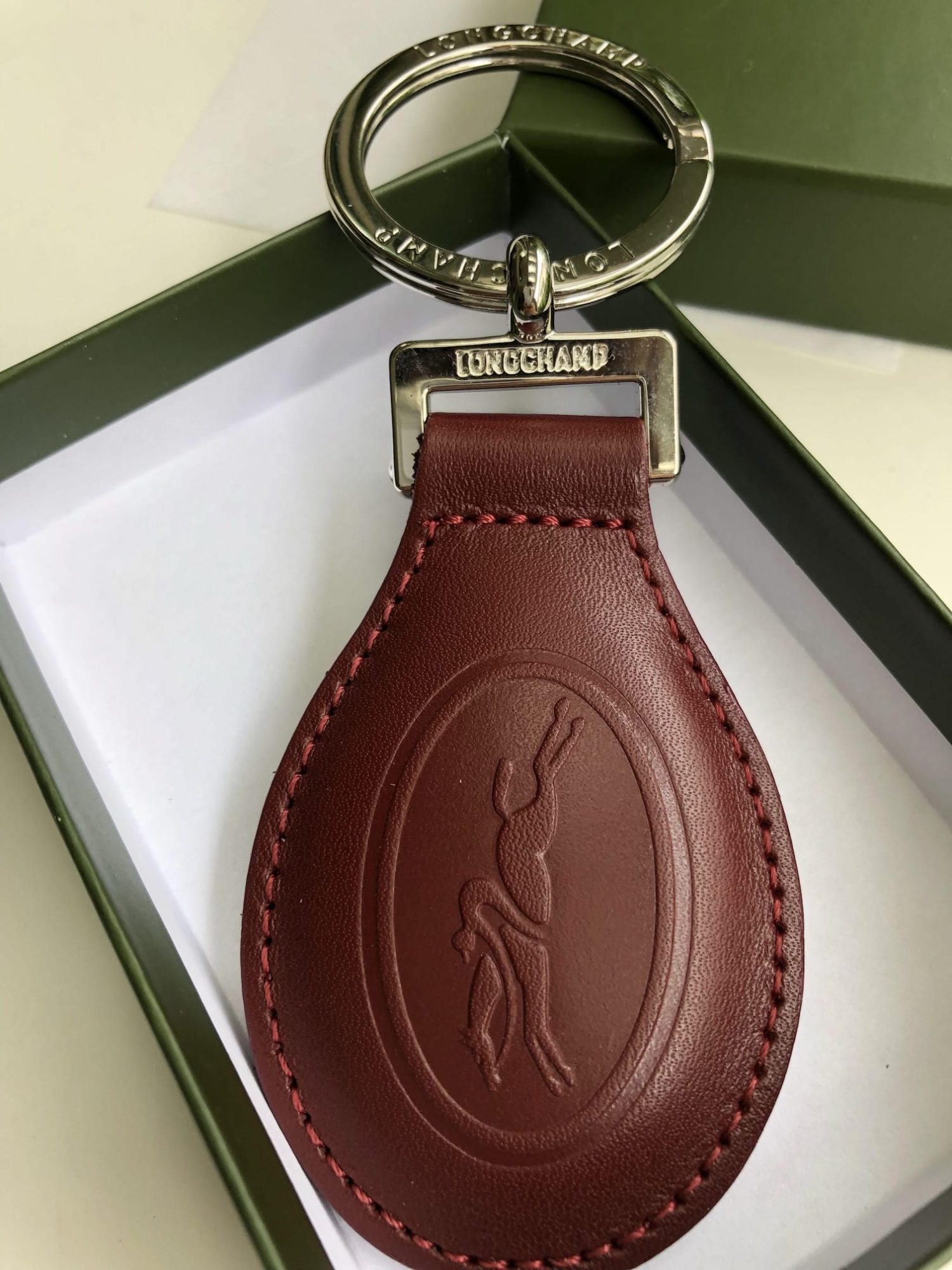 Close-up of a Longchamp key ring, highlighting the fine leather and logo detail